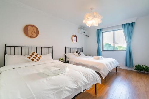 a bedroom with two beds and a window at Tonight Homestay West Nanjing Road Branch Shanghai in Shanghai