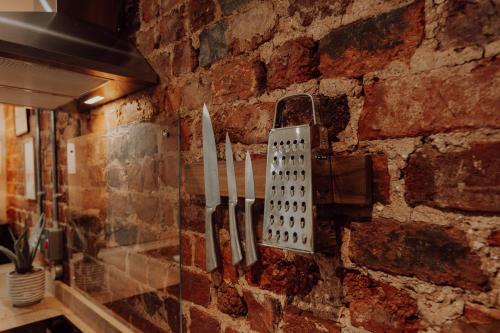 a wall with knives hanging on a brick wall at Newly Designed Home from Home in Retford in Retford