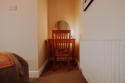 a chair sitting in front of a desk with a mirror at Newly Designed Home from Home in Retford in Retford