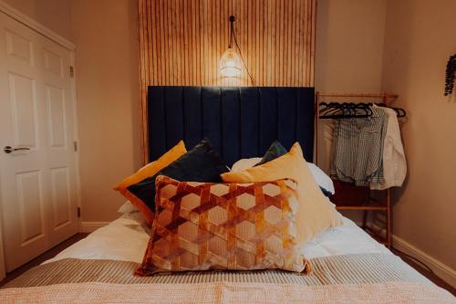 a bedroom with a bed with a blue headboard and pillows at Newly Designed Home from Home in Retford in Retford