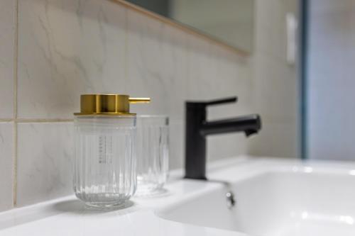 a plastic container with a gold top sitting on a sink at S1 SWEET HOMES Angoulême I Secteur Champs de Mars I Studio 2 couchages - Animaux acceptés in Angoulême