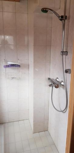 a shower with a shower head in a bathroom at Cozy cottage on lake in Iokela