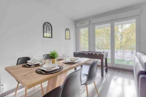 une salle à manger avec une table et des chaises en bois dans l'établissement Le Disneyland - Parking gratuit, à Montévrain