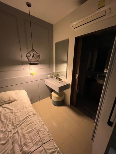 a bedroom with a sink and a bed and a mirror at Palmyrah Surin Beach Residence in Ban Lum Fuang