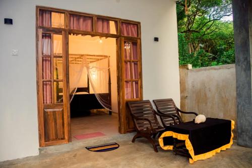 a room with two chairs and a table and a doorway at Thatched Villa in Tangalle