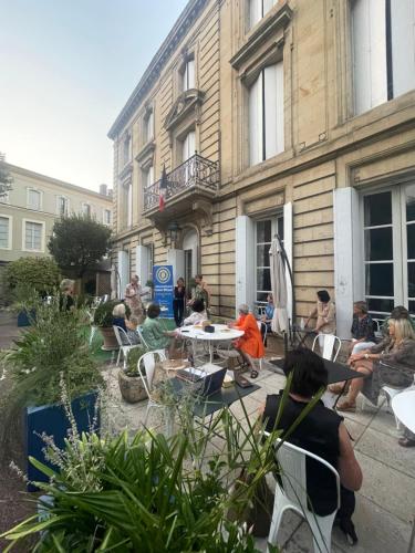 a group of people sitting around a table in front of a building at Hôtel Château des Jacobins in Agen
