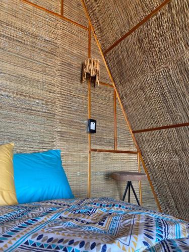 a bedroom with a bed in a straw wall at Sukoon Nuweibaa in Nuweiba