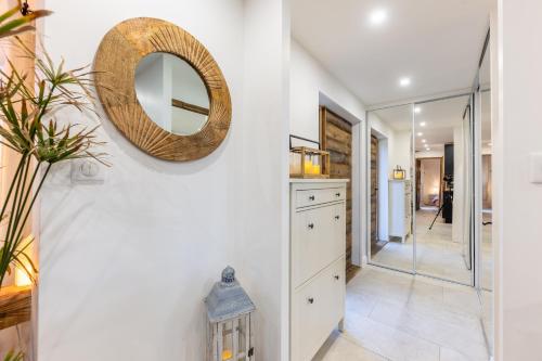 une cuisine avec des armoires blanches et un miroir au mur dans l'établissement Chalet Hohneck - Le lodge - Spa, borne de recharge, à Stosswihr