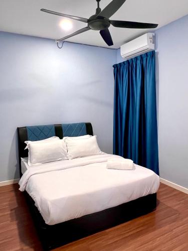 a bedroom with a bed with a ceiling fan at Hermosa Homestay in Lahad Datu