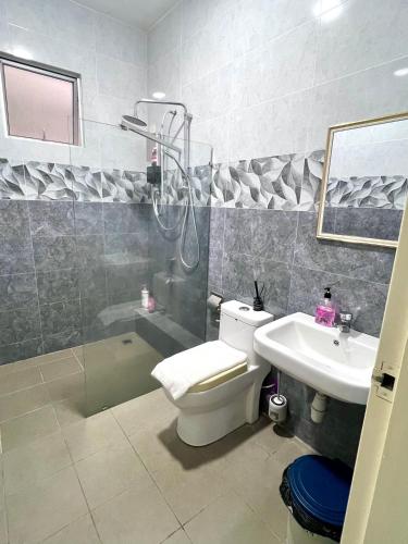 a bathroom with a shower and a toilet and a sink at Hermosa Homestay in Lahad Datu