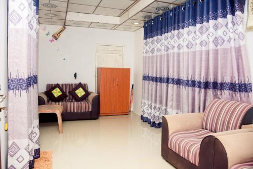 a living room with two couches and curtains at Thatched Villa in Tangalle