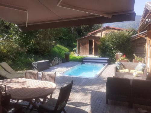 un patio avec une table et des chaises et une piscine dans l'établissement Chalet Hohneck - Le lodge - Spa, borne de recharge, à Stosswihr
