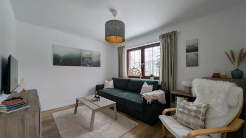 a living room with a couch and a chair at Ferienwohnung Pöhlwasserblick in Pöhla