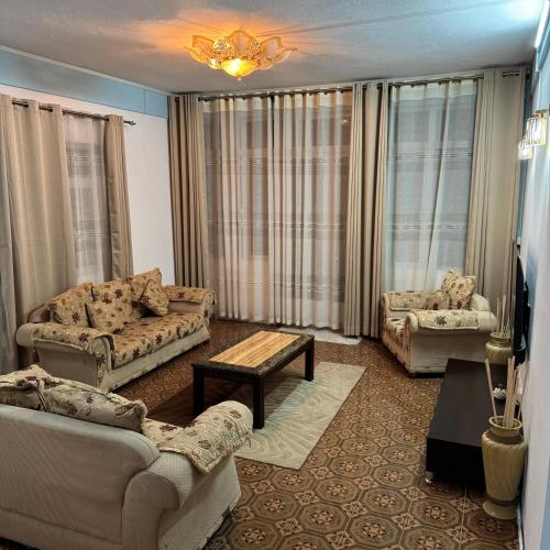 a living room with couches and a table in a room at Spacious Mauritian Home Centrally Located in Highlands