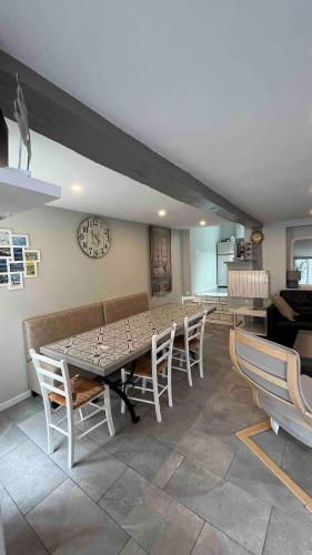 une salle à manger avec une table, des chaises et une horloge dans l'établissement Spacieuse Maison Bleue, au centre des Cordiers, au Tréport