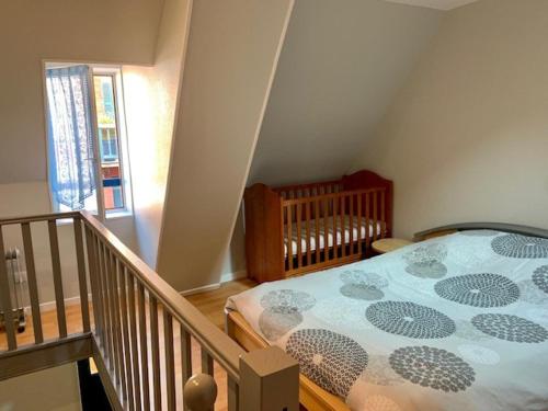 a bedroom with a bed and a crib in it at Spacieuse Maison Bleue, au centre des Cordiers in Le Tréport