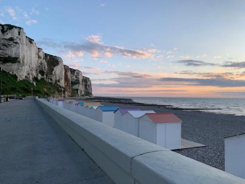 a row of beach huts on a rocky beach at Spacieuse Maison Bleue, au centre des Cordiers in Le Tréport