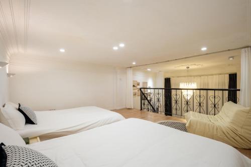 a bedroom with two beds and a balcony at Tonight Homestay West Nanjing Road Branch Shanghai in Shanghai