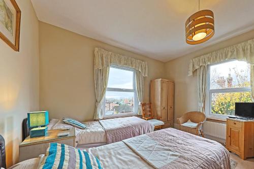 a bedroom with two beds and a window at Sunny Bank Guest House in Hythe