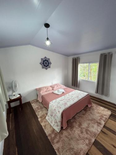 a bedroom with a bed and a window at Refúgio do Tucano in Alto Paraíso de Goiás