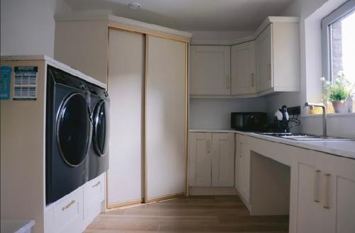 a kitchen with a washer and dryer on a counter at Teach Susie Portnoo Accessible Holiday Home with Assistive Equipment in Portnoo