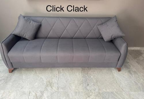 a grey couch in a room with the words click clack at Studio plein centre-ville ! in Fès