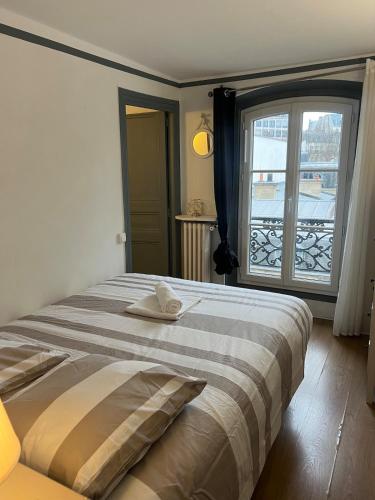une chambre avec un lit et une grande fenêtre dans l'établissement Appartement proche Champs Élysée Paris 8e, à Paris