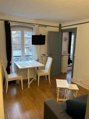 un salon avec une table et des chaises dans l'établissement Appartement proche Champs Élysée Paris 8e, à Paris