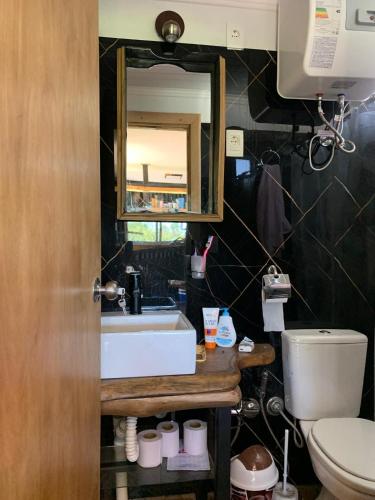 a bathroom with a sink and a toilet and a mirror at ClariCri in La Pedrera