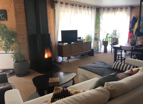 a living room with a couch and a fireplace at La Maison Mimosa - Espace, Confort et Proche Plage in Portbail