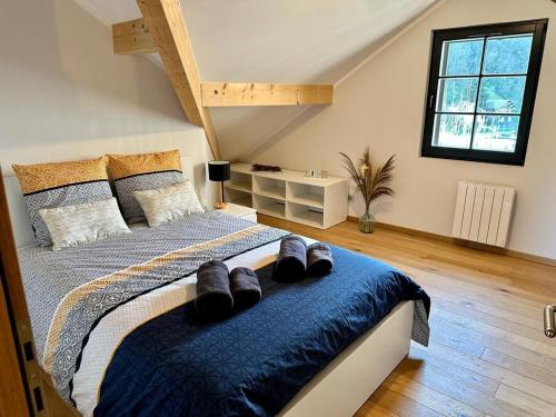 une chambre avec un lit avec des chaussures dessus dans l'établissement Appartement, 20m du lac Conjux, vue lac, à Conjux