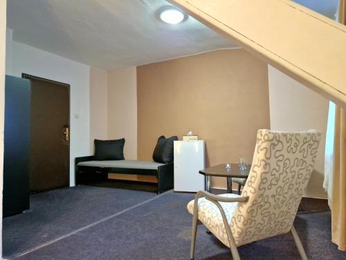 a room with a chair and a table and a couch at Penzion Stavař in Vrbno pod Pradědem