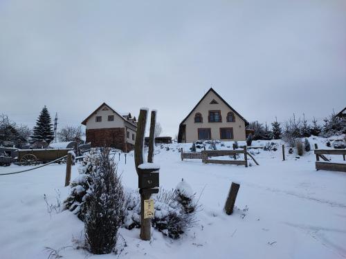 a snow covered yard with houses and a parking meter at Apartmán na statku Červený Kostelec in Červený Kostelec