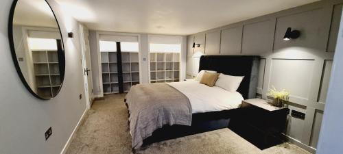 a bedroom with a large bed and a mirror at 5 Oban in Oban