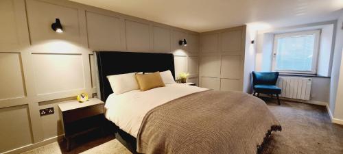 a bedroom with a large bed and a blue chair at 5 Oban in Oban