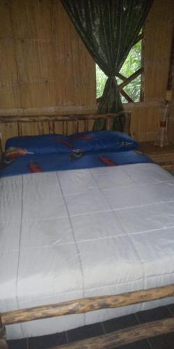a large bed in a room with atained at Cabanas Armonia in Cotundo