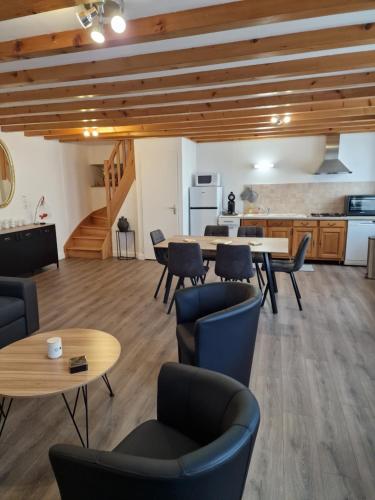 une grande pièce avec tables et chaises et une cuisine dans l'établissement Maison charmante quartier historique, à Langres