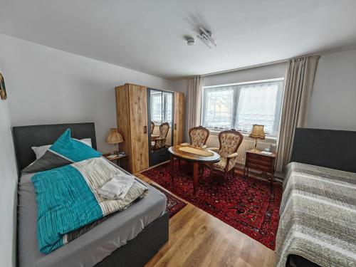 a bedroom with a bed and a table and chairs at Apartment E1 - Gut ausgestattete 3-Zimmerwohnung 68 qm für 1-5 Personen 2xZZ 1xSC in Gravenwerth