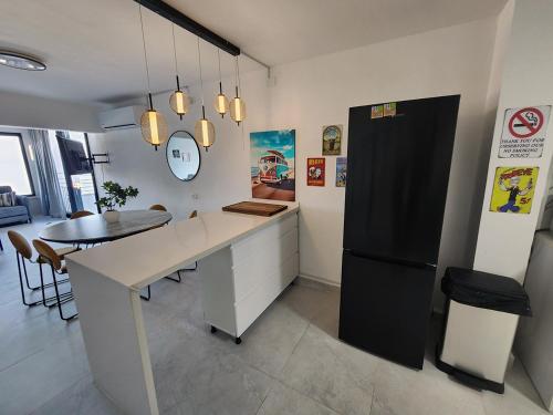 a kitchen with a table and a black refrigerator at דופלקס כנרת in Tiberias