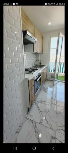 - une cuisine avec un sol en marbre et une cuisinière four supérieur dans l'établissement 3 pièces bord de mer, à Nice