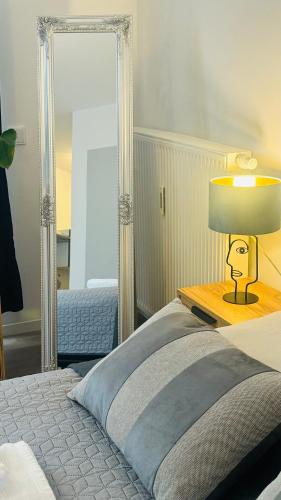 a bedroom with a bed with a lamp and a mirror at Ferienwohnung Jurga in Pirna