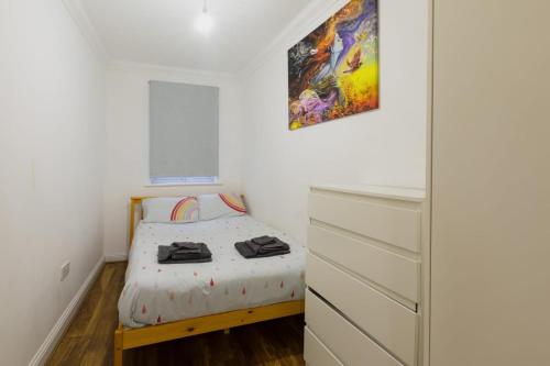 a small bedroom with a bed and a dresser at Ocean waves apartment near Bournemouth beach in Bournemouth