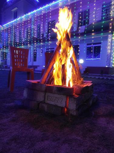 a fire pit in front of a building with lights at Sea Smile Inn in Mandarmoni