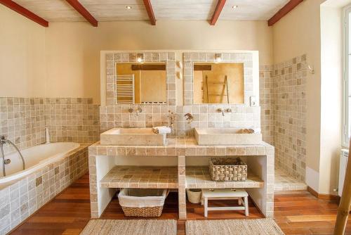 Mas des Olivades - Ferme Provençale - Piscine في بيرنيه لو فونتينز: حمام فيه مغسلتين وحوض استحمام ودوبي