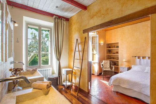 Mas des Olivades - Ferme Provençale - Piscine في بيرنيه لو فونتينز: غرفة نوم بسرير وحمام مع حوض