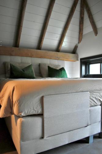 a bedroom with a large white bed with green pillows at Huisje over de IJssel in Zwolle