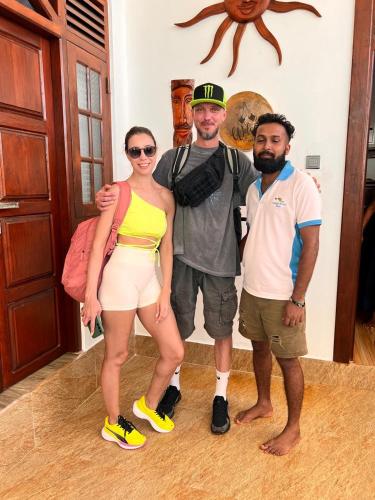 a group of three people posing for a picture at Ocean Front Villa in Hikkaduwa