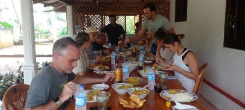 a group of people sitting at a table eating food at Glitz Marriott in Deniyaya