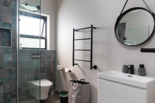 a bathroom with a toilet sink and a mirror at SuPaViews in Wilderness