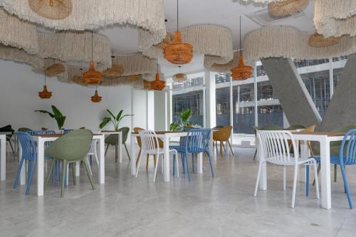 a restaurant with white tables and chairs and windows at Hotel porto horizonte suite 329 Santa Marta in Playa Bello Horizonte
